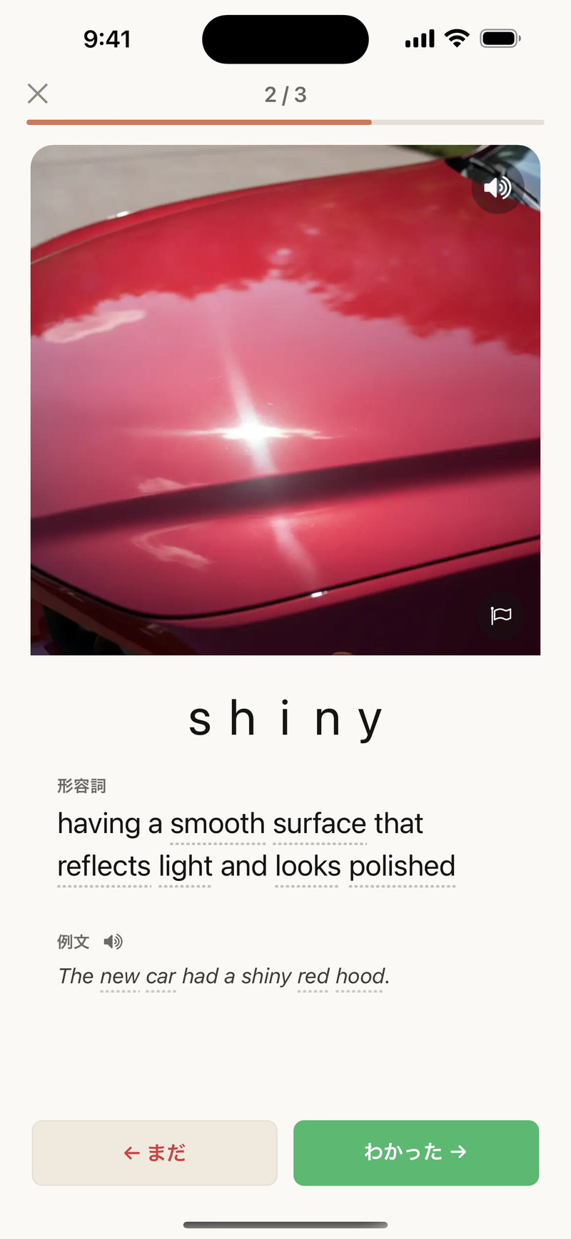 「shiny」の学習カード。光を反射してきらめく赤い車体の写真とともに、やさしい英語の定義と例文が並んでいる。